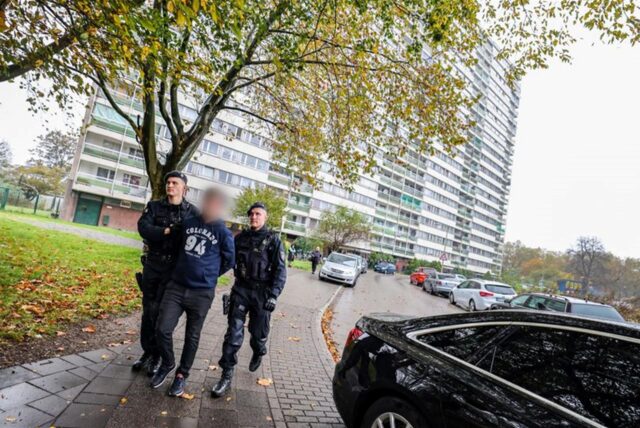 Bei einer Meldekontrolle durch verschiedene Behörden am Problem-Hochhaus «Weißer Riese» im Stadtteil Homberg wird ein Mann in Handschellen von der Polizei abgeführt.