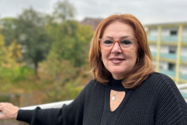 Liliana Roth lehnt an einem Geländer und schaut in die Kamera