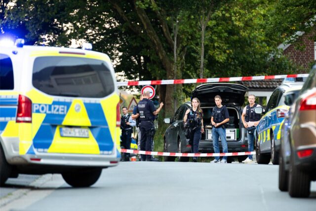 Einsatzkräfte der Polizei stehen an einem Tatort zwischen Fahrzeugen. Bei einem Schusswaffeneinsatz der Polizei ist ein mutmaßlicher Messerangreifer tödlich getroffen worden.