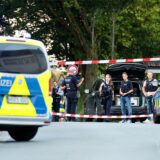 Einsatzkräfte der Polizei stehen an einem Tatort zwischen Fahrzeugen. Bei einem Schusswaffeneinsatz der Polizei ist ein mutmaßlicher Messerangreifer tödlich getroffen worden.