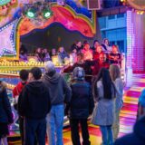 Kirmesbesucher warten vor dem Musikexpress auf der Kirmes in Unna auf die nächste Runde.