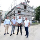 Vier Männer stehen vor einem Rohbau in Marl.