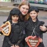 Eine Frau und zwei Kinder mit Lebkuchenherzen „Katharinenkirmes 2024“ stehen auf dem Rathausplatz in Unna.