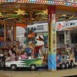 Am Eröffnungstag der Katharinenkirmes in Unna halten eine Frau und zwei Kinder in Halloween-Kostümen Lebkuchenherzen in den Händen.
