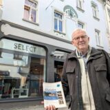 Dr. Gernot Folkers steht vor der Boutique Select in Schwerte. Er hält ein Heftchen mit der Aufschrift „Elsetaler“ in der Hand.