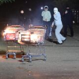 Junge Männer, teils vermummt, schieben brennende Einkaufswagen in Richtung der Einsatzkräfte.