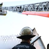 Ein Feuerwehrmann steht bei einem Einsatz bei einem Brand an einer Drehleiter. (Symbolbild)