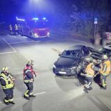 Auf dem Bild sieht man einen Unfall, bei dem zwei Autos zusammengestoßen sind. Die Feuerwehr ist vor Ort mit einem Löschwagen.