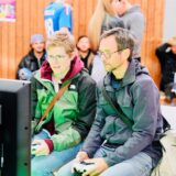 Zwei Besucher des F4 Gaming-Festivals 2024 in Schwerte sitzen an einer Konsole.