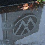 In einer Pfütze vor dem VW-Werk Kassel in Baunatal spiegelt sich das Firmenlogo.