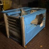 Eine abgebrannte Dixi-Toilette, die auf der Seite liegt.