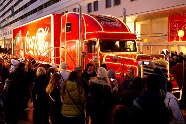 Menschen stehen vor dem Coca-Cola Weihnachtstruck.