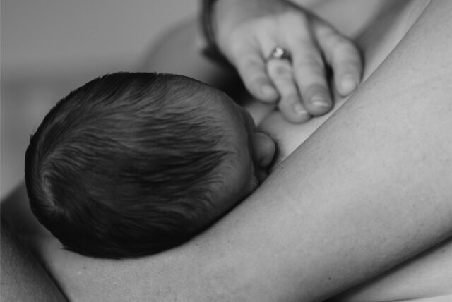 Ein Baby wird von seiner Mutter gestillt.