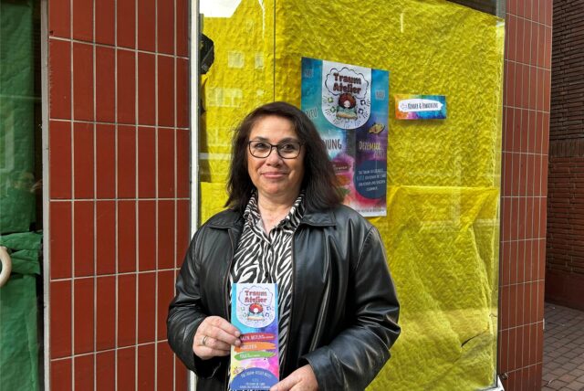 Monica Urquiola-Abdinghoff hält einen Flyer ihres Unternehmens in Händen.