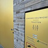 Eine goldene Tür und ein ebenso goldenes Hinweisschild weisen auf die öffentliche Toilette im Rat- und Bürgerhaus hin.