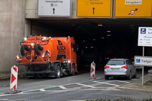 Ein signalrotes Reinigungsfahrzeug fährt in den Ringtunnel in Unna