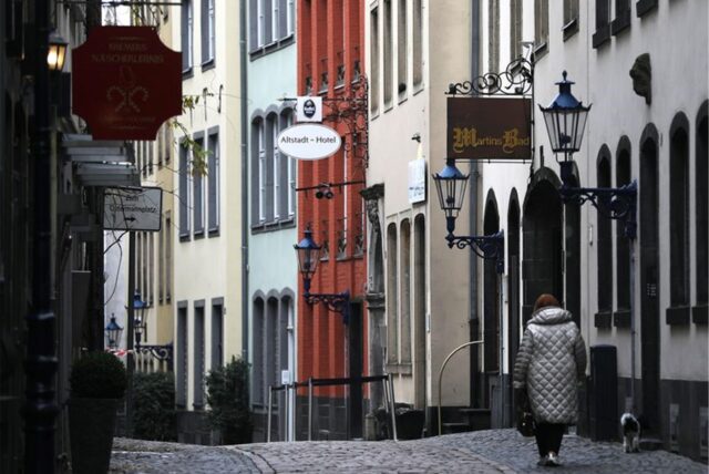 Eine Frau geht mit Hund durch die Gasse der Altstadt.