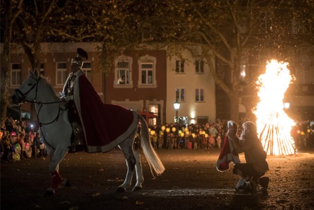 Der „Heilige Sankt Martin“ teilt im Anschluss an einen Martinsumzug seinen Mantel mit einem „Bettler“.