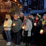 Menschen halten Kerzen in Händen.