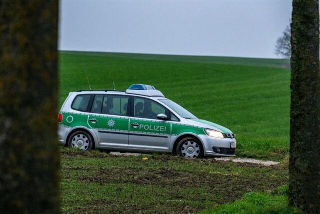 Polizisten sichern die Zufahrtsstraße zum Tatort eines Tötungsdelikt.