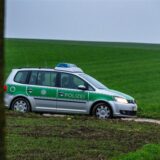 Polizisten sichern die Zufahrtsstraße zum Tatort eines Tötungsdelikt.