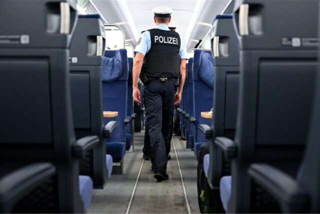 Bundespolizisten gehen durch einen ICE der Deutschen Bahn.