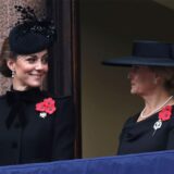 Prinzessin Kate (links) und Herzogin Sophie (rechts), in Schwarz gekleidet, mit Hüten und roten Ansteckern.