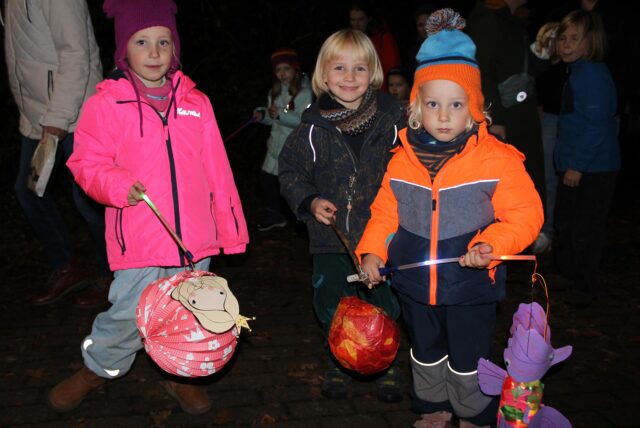 Drei Kinder halten beim Martinsumzug in Föndenberg-Dellwig ihre Laternen in der Hand.