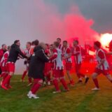 Die Spieler des TuS Hemmerde tanzen zum Derbysieg. Im Hintergrund zünden die mitgereisten Fans Pyro.