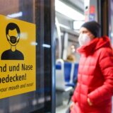 Eine Frau steigt mit FFP2-Maske in eine Trambahn ein.