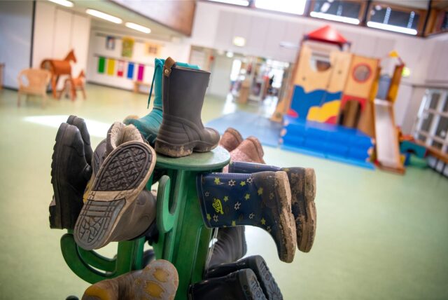 Stiefel hängen auf einem Ständer in einer Kita.