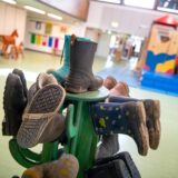 Stiefel hängen auf einem Ständer in einer Kita.
