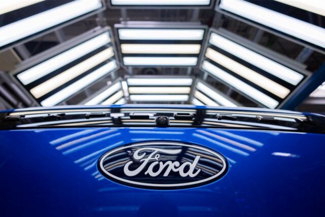 Ein Logo mit der Aufschrift „Ford“ auf der Karosserie eines blauen Autos.
