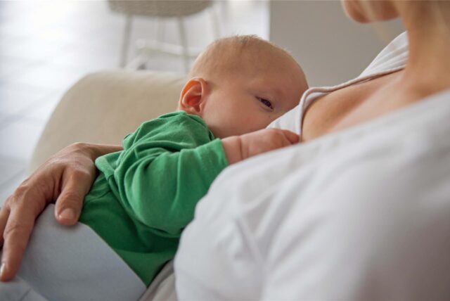 Eine Frau stillt ihr Baby.