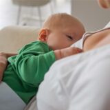 Eine Frau stillt ihr Baby.