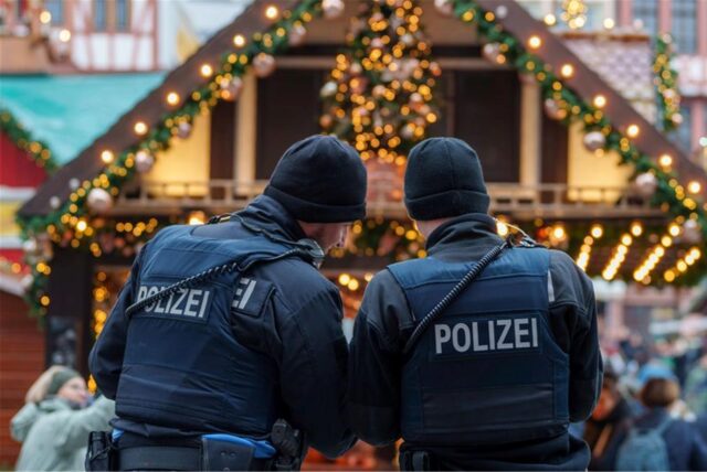 Zwei Polizisten stehen auf dem Weihnachtsmarkt in Frankfurt.