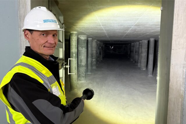 Bernd Heinz, Geschäftsführer von Wasserwerke Westfalen GmbH,  leuchtet mit einer Taschenlampe in den Zwischenspeicher für das aufbereitete Wasser.