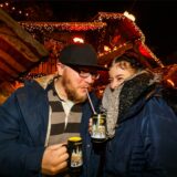Zwei Besucher des Dortmunder Weihnachtsmarktes trinken Glühwein und Lumumba aus der speziellen Dortmunder Weihnachtsmarkt-Tasse.