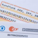 Ein Anschreiben zur Anmeldung für die Rundfunkgebühren liegt auf einem Überweisungsträger.