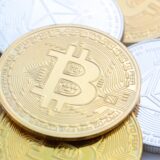 Bitcoin (M) und Ethereum-Münzen sind auf einem Tisch angeordnet.