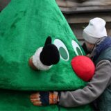 Der Angeklagte umarmt vor dem Strafjustizgebäude eine Person in einem Weihnachtsbaumkostüm.