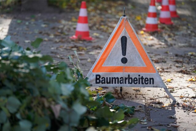 Warnschild wegen Baumarbeiten steht auf dem Boden.