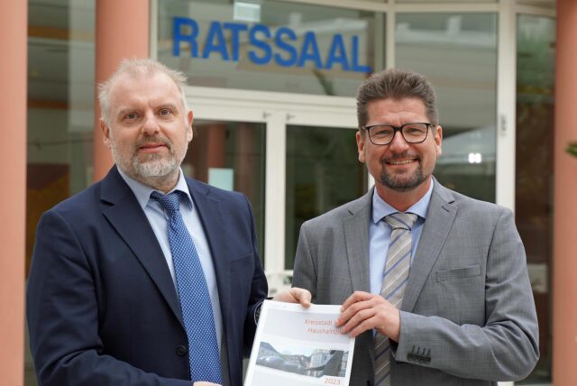 Bürgermeister Dirk Wigant (l.) und Stadtkämmerer Michael Strecker präsentieren in der Bürgerhalle des Unnaer Rathauses eine gedruckte Ausgabe des Haushaltsplans.