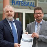 Bürgermeister Dirk Wigant (l.) und Stadtkämmerer Michael Strecker präsentieren in der Bürgerhalle des Unnaer Rathauses eine gedruckte Ausgabe des Haushaltsplans.