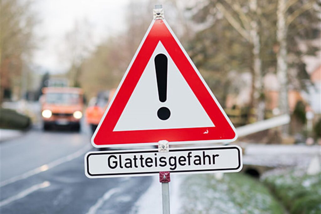 Ein Schild weist auf Glatteisgefahr hin. Ein Schild weist auf Glatteisgefahr hin.