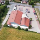 Montage aus Luftbild eines Feldes hinter einem Gebäude mit rotem Dach und Ralf Klute von der Feuerwehr Oberaden.