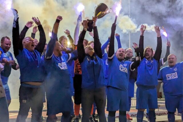Die Mannschaft feiert mit Rauchfackeln den Pokal der Übergewichtigen Liga NRW.