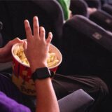 Ein Kind isst Popcorn in einem Kinosaal.