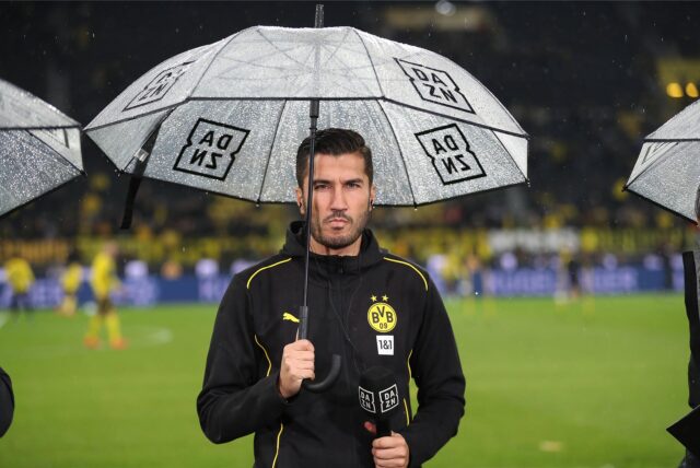 Nuri Sahin hält einen Schirm in der Hand.