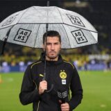 Nuri Sahin hält einen Schirm in der Hand.